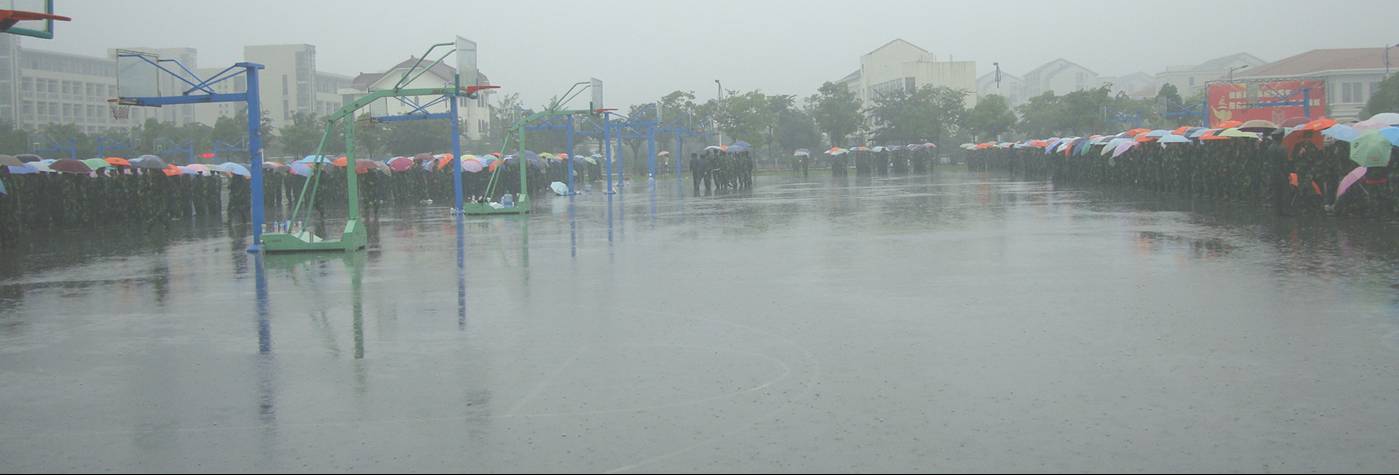 Picture:  Freshmen take their military training in the pouring rain.  Jiangnan University, Wuxi, China