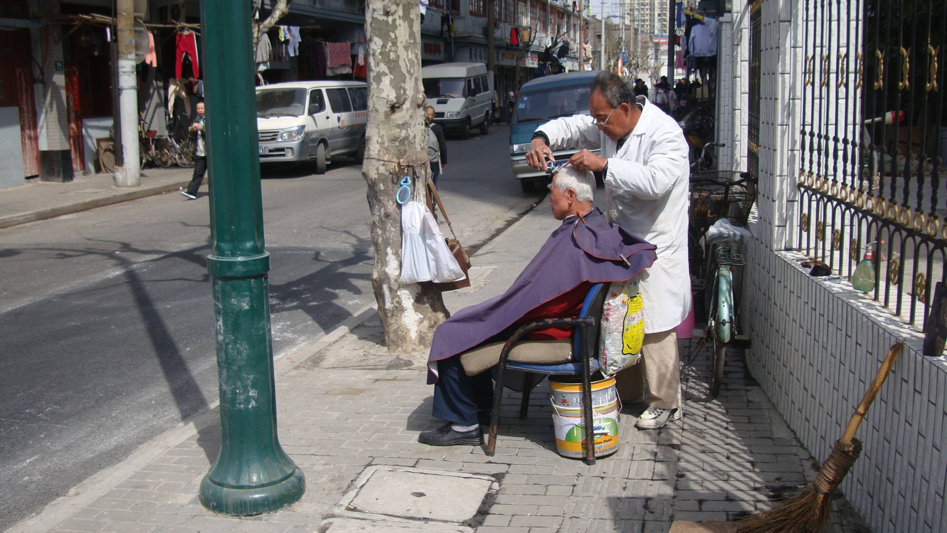 Shanghai barber at work on the street.  Shanghai, China.  The very definition of low overhead.