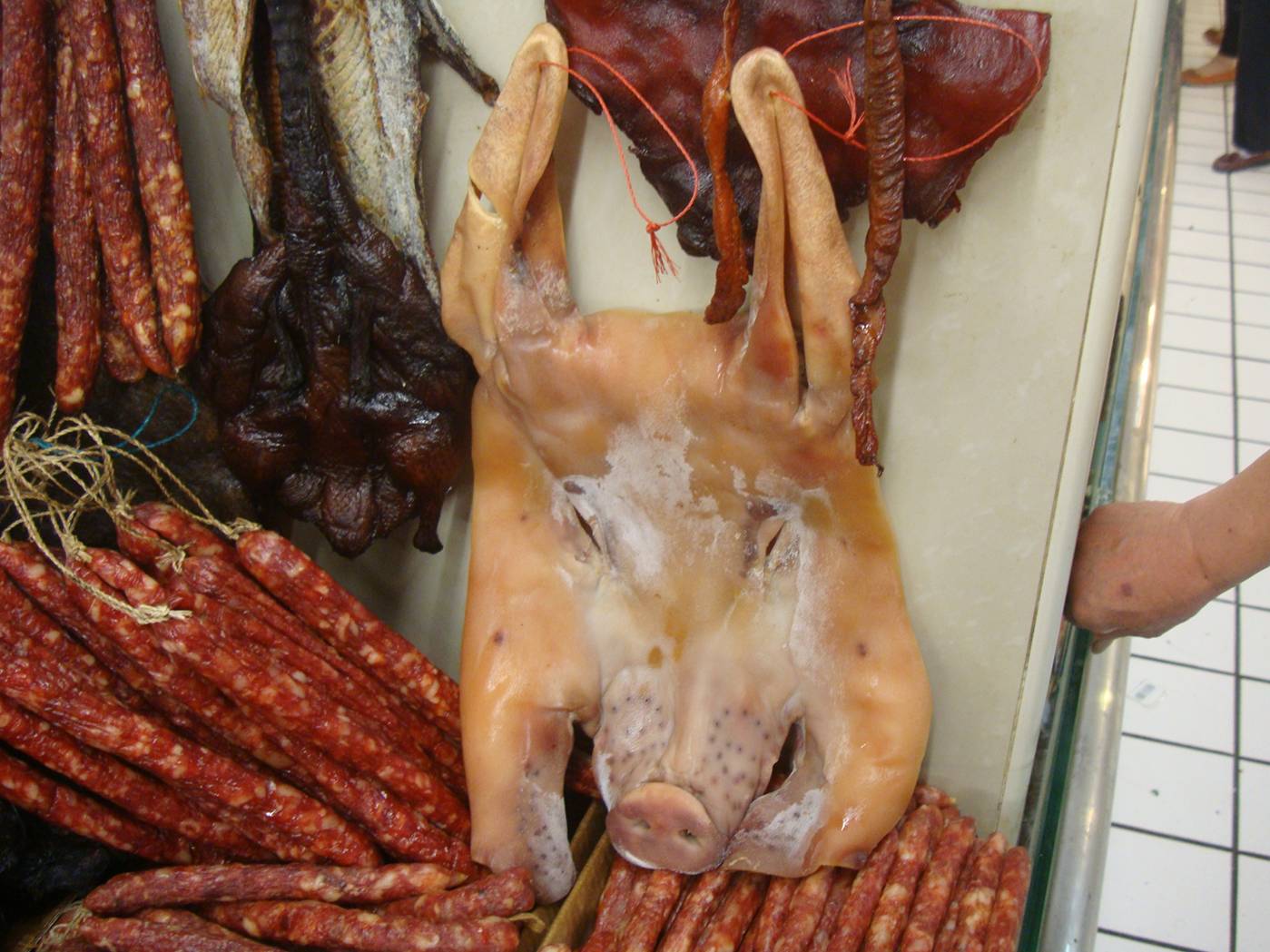 Picture:  A pig's face in the meat market.  The kind of thing that foreigners find hideous, like "Silence of the Lambs" has come to the world of pork.  Wuxi, China