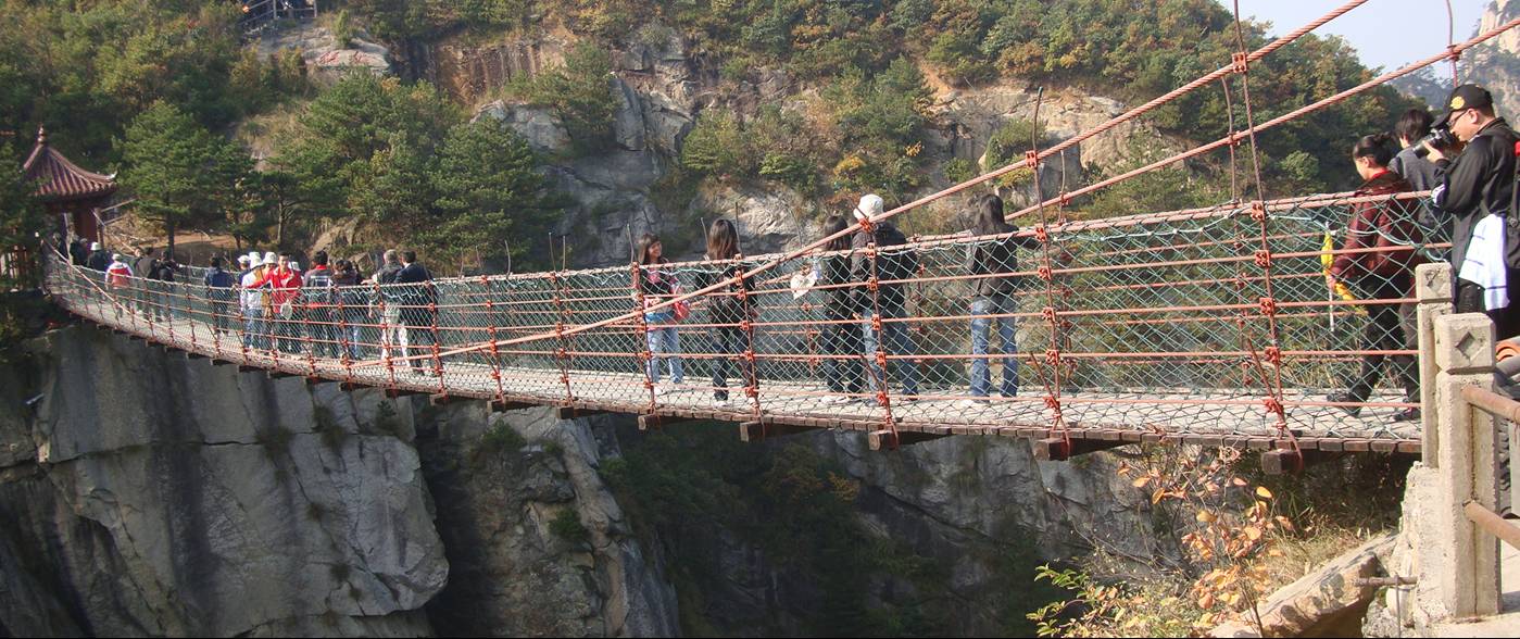 Picture: The suspended cable foot bridge between peaks at Daming Shan (Big Clear Mountain), Zhejiang, China