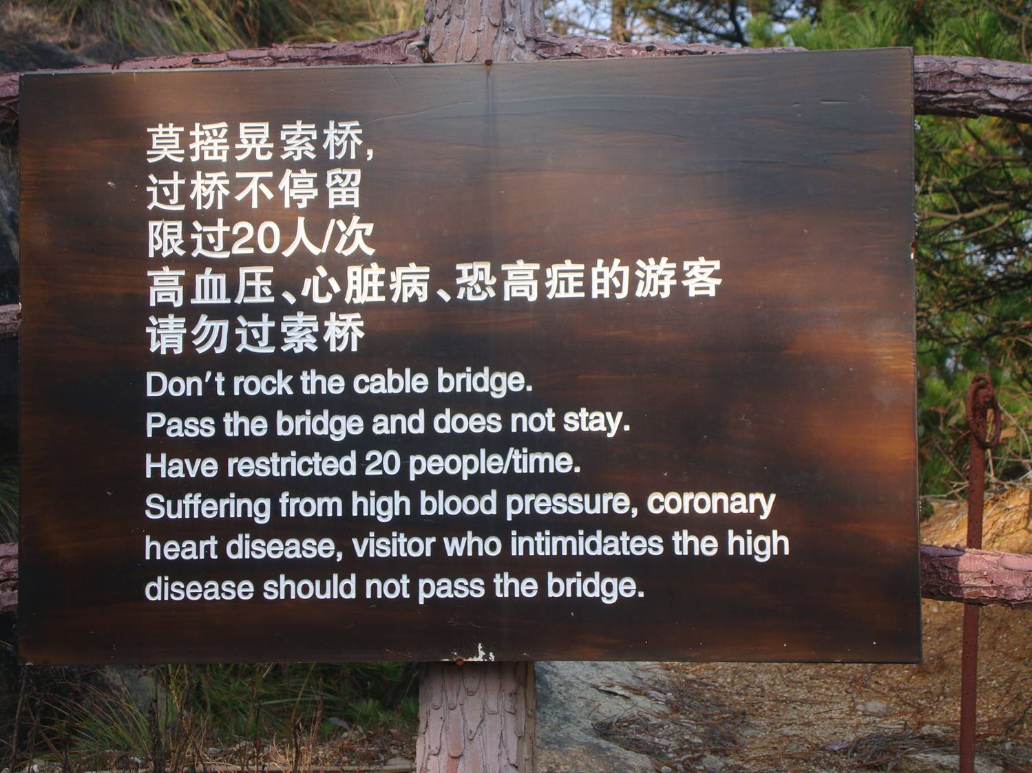 Picture:  I love it when Chinglish is written on stone or wood.  Warning sign at the cable suspended foot bridge, Daming Shan, Zhejiang, China