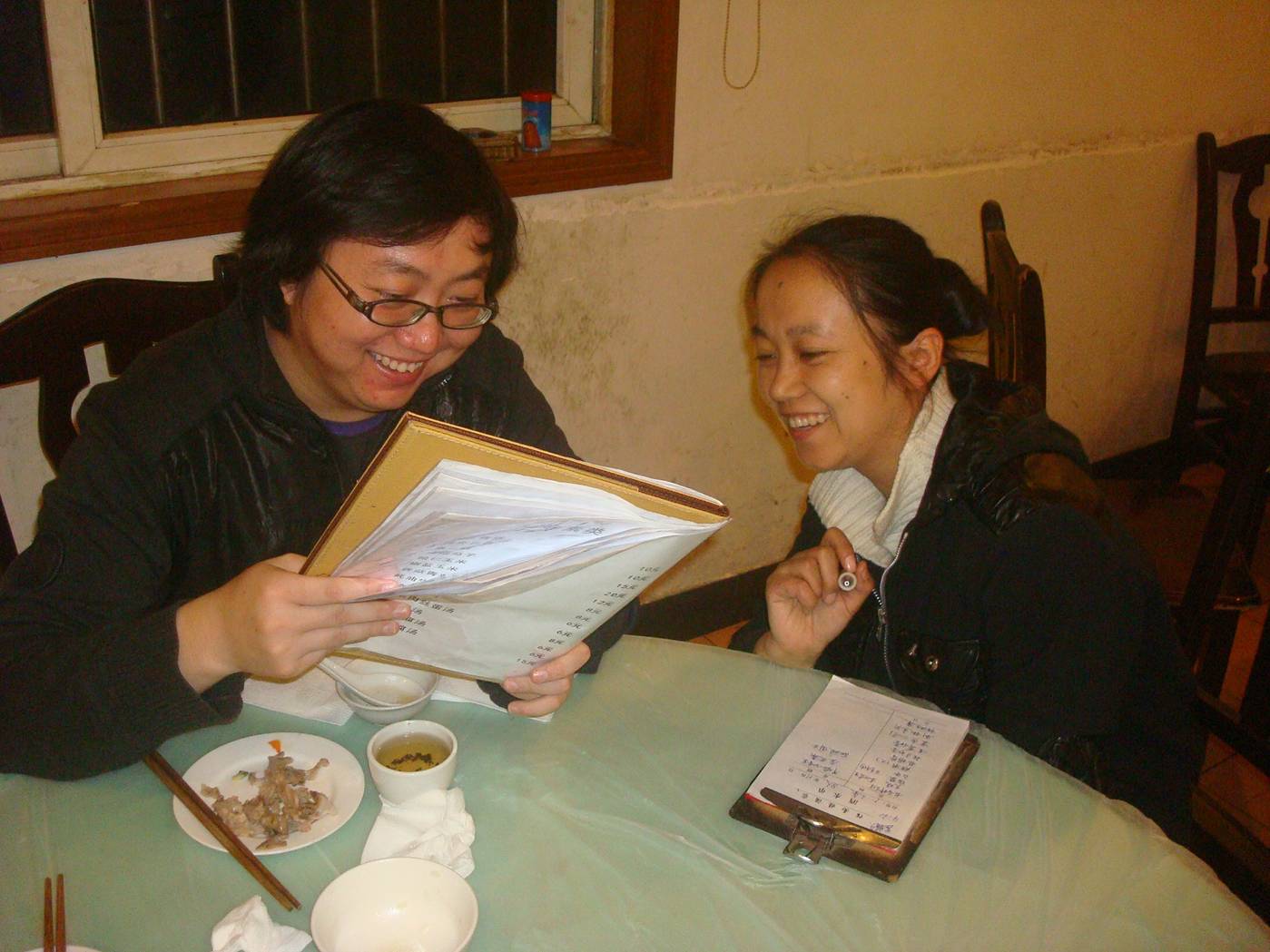Picture:  Jin Bo consults with the restaurant manager, and orders about twice as much food as required.  Which is customary and no problem.  Shitang Cun, Wuxi, China