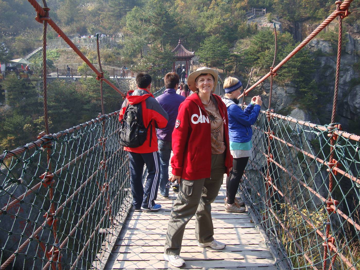 Picture:  Ruth pauses to have her picture taken on the cable foot bridge.   Daming Shan, Zhejiang, China