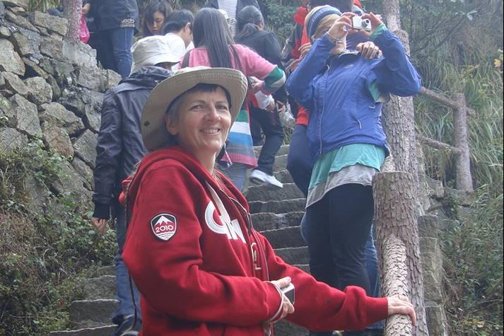 Picture:  Ruth pauses to have her picture taken on stairs up to the cable foot bridge.   Daming Shan, Zhejiang, China