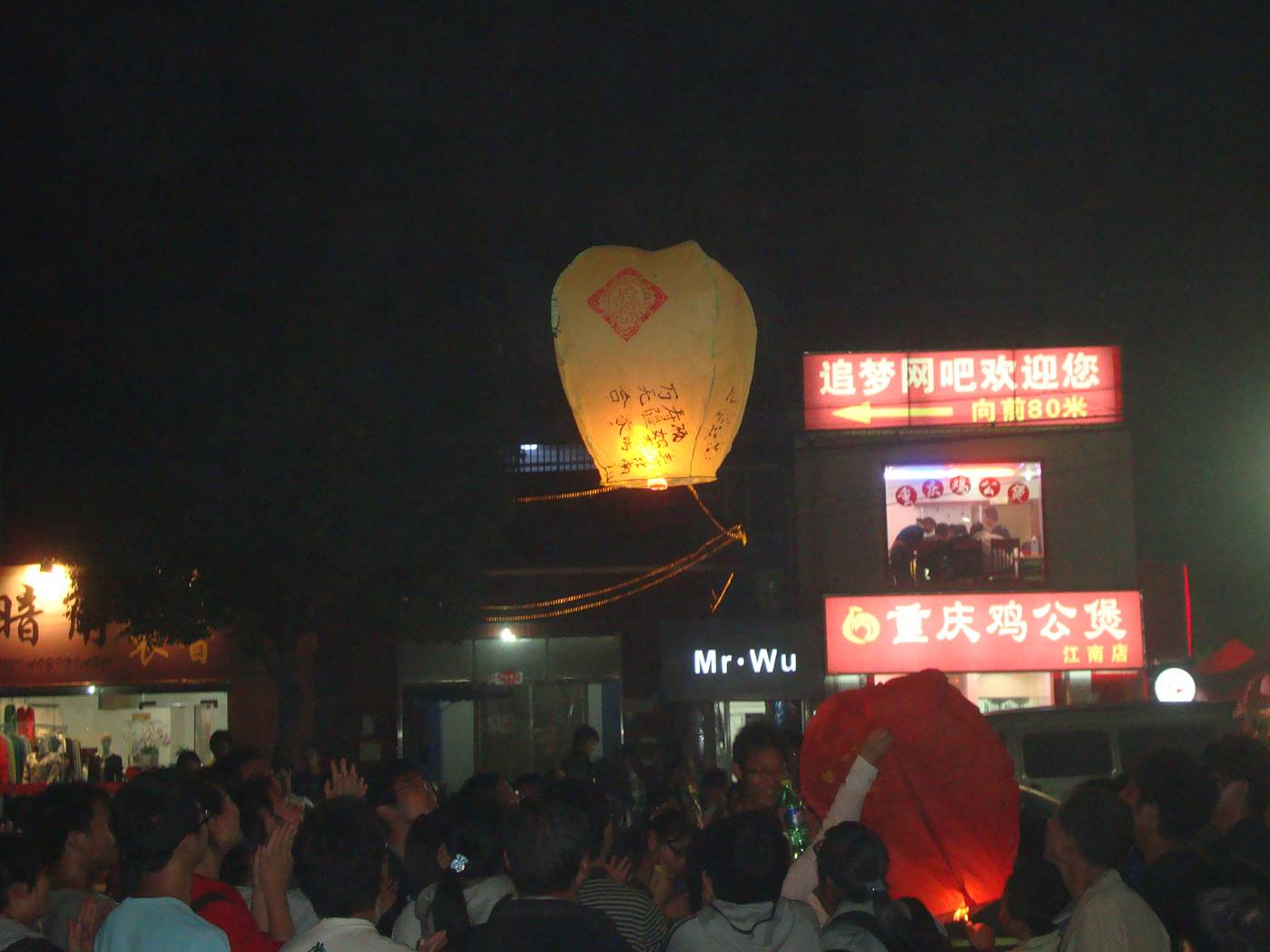 Picture: A fire balloon rises above the crowd.  It's a good thing that none of the roofs here are flammable.
