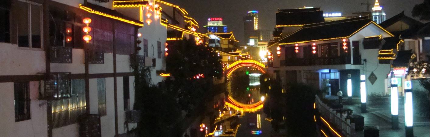 picture:  The Temple Market area in downtown Wuxi glows and sparkles at night with the lights reflected in the canal.